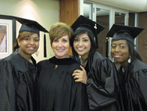 Students in cap and gown with instructor